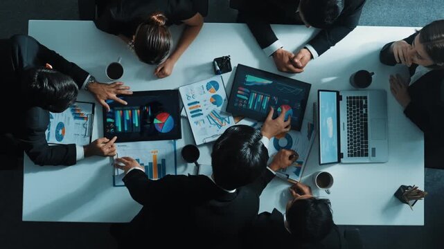 Top down aerial view of smart project manager present growth graph while marketing team analyze chart at meeting table with.laptop, tablet and stock market financial statistic document. Directorate.
