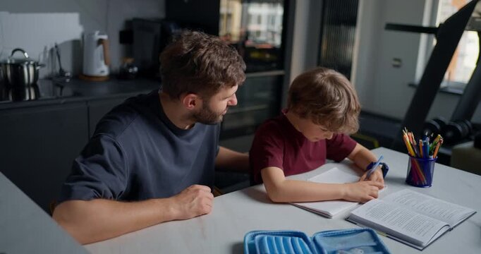 Father And Son Share Cheerful Learning. Parent And Child Engaging In Joyful Study Session At Home