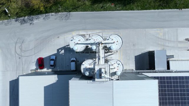 Aerial view of Foamed Glass UK Industrial Factory with large white silos, parked cars, and solar panels on the roof in Great Heck, England, United Kingdom.