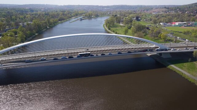 Aerial view of modern Troja Bridge with public transport tram and bus crossing Vltava river toward Hole&scaron;ovice district in Prague on a sunny day