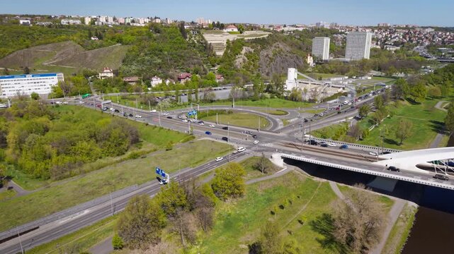 Cinematic aerial view of a complex highway intersection and the entrance to Blanka tunnel in the Prague-Troja district on a sunny day