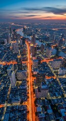 Obraz premium Illuminated Modern City Skyline Glowing at Sunset Beside Winding River