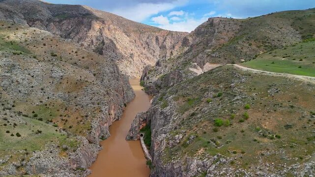 Aerial View of Train Tunnel Through Rocky Canyon with River