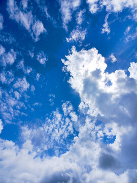 Dramatic Vertical View of Sun Hiding Behind Clouds with Silver Lining Effect