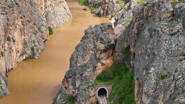Drone Shot of Railway Tunnel and Bridge in Rocky Canyon with River