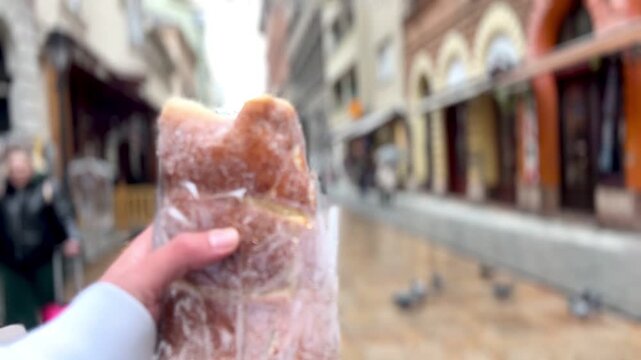 Tourist holding a traditional hungarian chimney cake