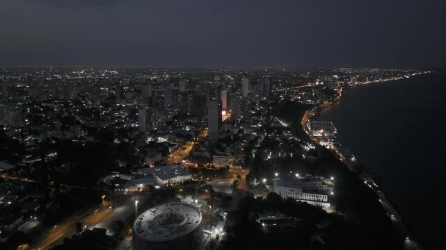 Drone flies north from coast to Polana Cimento A at night with the city lit up in Maputo, Mozambique