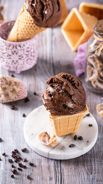 Delicious chocolate ice cream cone placed on a marble plate, surrounded by decorative items and a rustic wooden surface, creating a cozy atmosphere, stories templates with copy space