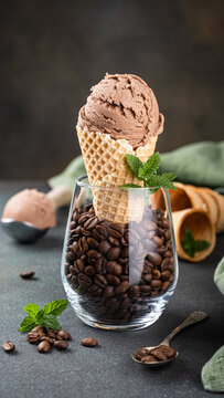 Delicious chocolate ice cream cone placed in a glass filled with roasted coffee beans and garnished with fresh mint leaves, stories templates with copy space