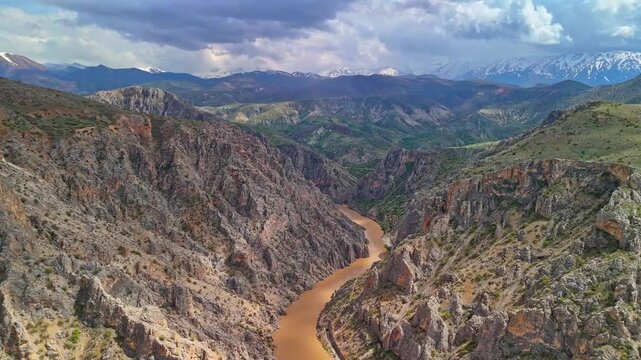 Aerial View of Canyon River and Mountain Landscape Under Dramatic Sky