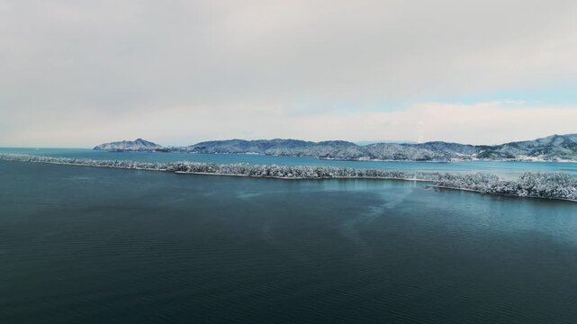 雪景色の天橋立 4Kドローン空撮 日本三景 松並木と青い海のコントラスト