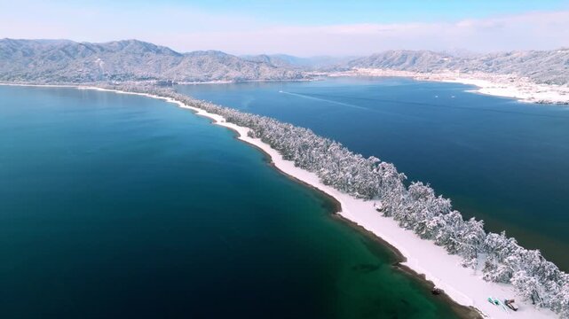 雪景色の天橋立 4Kドローン空撮 日本三景 松並木と青い海のコントラスト