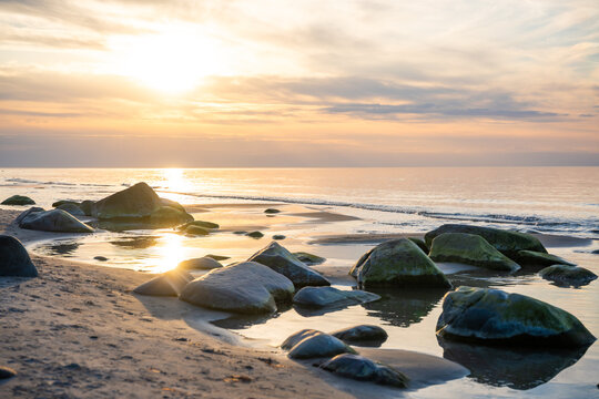 Rocky beach coastline on Ruegen island in Germany during sunset over the Baltic Sea. Travel, nature and seaside landscape with calm evening atmosphere