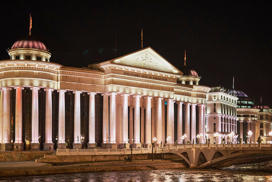 Archeological Museum of Macedonia and Art Bridge reflected in the Vardar River at night, Skopje, North Macedonia, Europe.