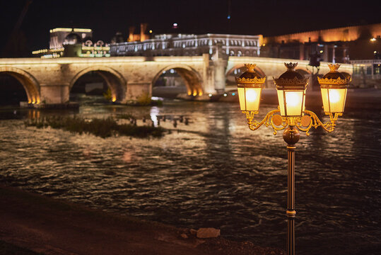 Ornate street lamps in the foreground with the Stone Bridge across the Vardar River at night, Skopje, North Macedonia, Europe.