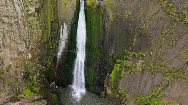 Aerial view of surroundings at Spekes Mill Mouth waterfall which is  located in a beautiful coast area of rugged valleys, high cliffs and wildflowers flourish. Drone POV of United Kingdom landscapes. 