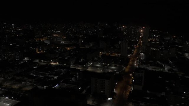 Drone flies east over downtown at night in Maputo, Mozambique