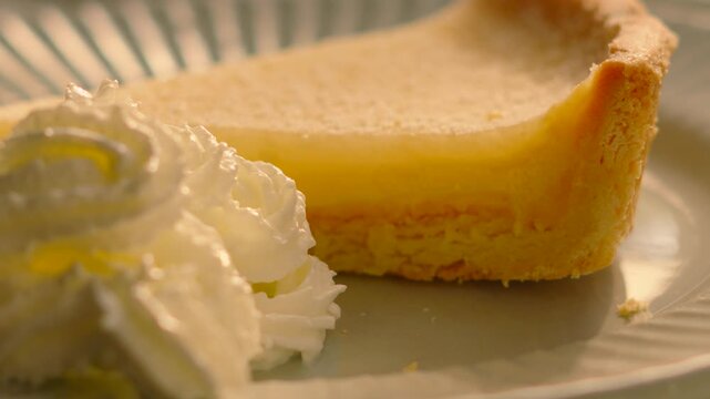 Close-up of a classic French Tarte au Citron on a Plate with Whipped Cream. Perfect for Food apps, social media montages, high-end restaurant promos. 4K.