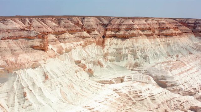 Drone reveals surreal moonlike canyon landscape in Bozzhyra Mangistau Kazakhstan formed from ancient ocean seabed, showing layered chalk and limestone cliffs shaped by millions of years of erosion