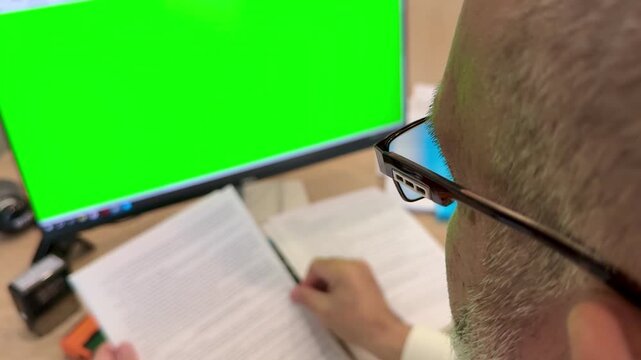  Office over‑the‑shoulder: reviewing papers by green‑screen monitor, 4K slow motion
