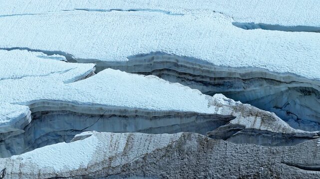 Panning drone shot of massive blue crevasses and seracs in the Mont Blanc massif, Chamonix, France