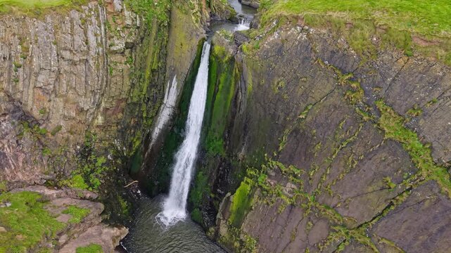 Aerial view of surroundings at Spekes Mill Mouth waterfall which is  located in a beautiful coast area of rugged valleys, high cliffs and wildflowers flourish. Drone POV of United Kingdom landscapes. 