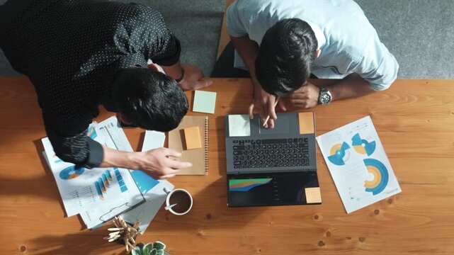 Top aerial view of business team working together to analysis data by using laptop on meeting table. Cooperative start up group discussing and brainstorming plan while looking at graph. Convocation.