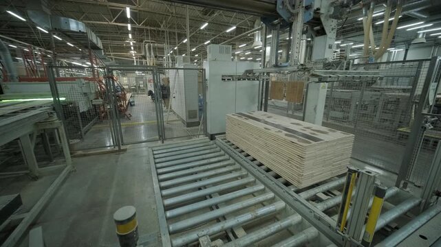 Close-up of an automated production line with timber slats in motion within a modern wood processing facility