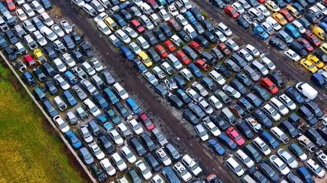 Cars parked in a vast area for sale. Many cars are parked closely together in a large outdoor space at a used car lot during daytime.