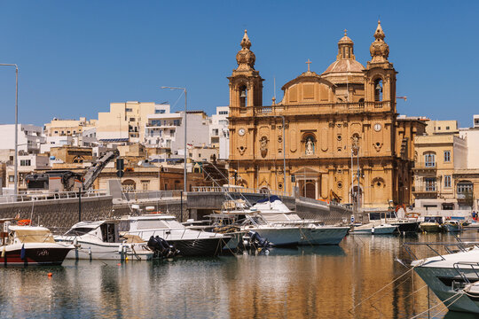 Neo-gothic church in Balluta Bay Malta with leisure boats