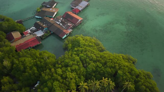 Aerial landscape of a traditional coastal fishing village with stilt houses and aquaculture