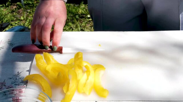 yellow bell pepper in sunlight cut pepper cut into pieces with a knife. Cooking vegetable dishes. High quality 4k footage