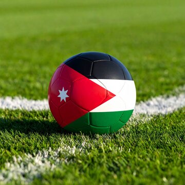 Soccer ball on a green field with the Jordan flag on it