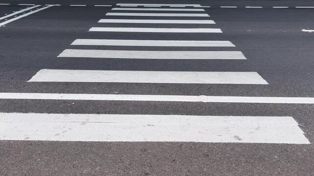 Urban traffic moving past a zebra crossing on a city road, capturing everyday transportation, mobility, and street activity