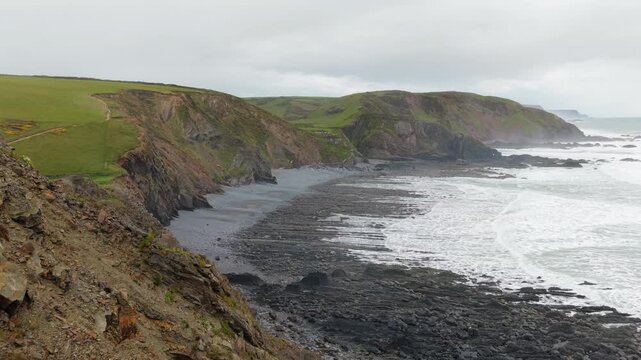 Aerial view of surroundings at Spekes Mill Mouth waterfall which is  located in a beautiful coast area of rugged valleys, high cliffs and wildflowers flourish. Drone POV of United Kingdom landscapes. 
