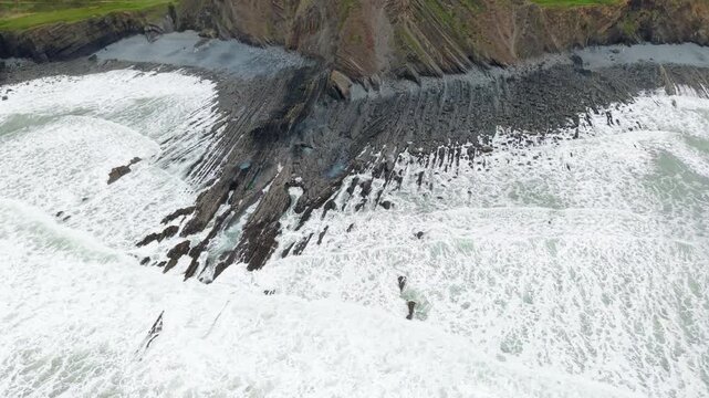 Aerial view of surroundings at Spekes Mill Mouth waterfall which is  located in a beautiful coast area of rugged valleys, high cliffs and wildflowers flourish. Drone POV of United Kingdom landscapes. 