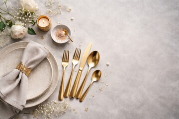 Naklejka premium Stylish table decor incorporating golden cutlery on a gentle grey textured background plus copy space