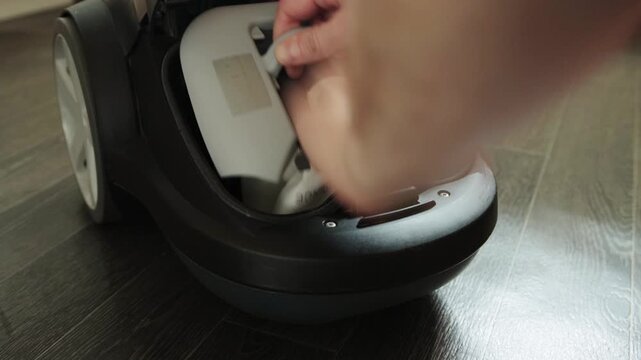 Close-up perspective of hands meticulously inserting fresh dust collection bag into vacuum cleaner interior. This essential maintenance step ensures appliance operates at peak efficiency, preventing d
