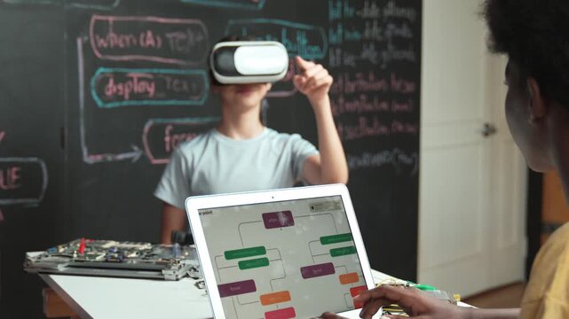 African boy programming system while caucasian girl enter metaverse while sitting at blackboard with engineering code written.high school girl wearing VR or headset in STEM technology. Edification