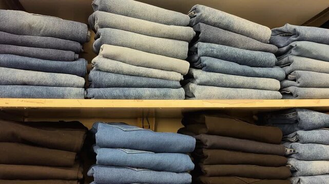 neatly stacked denim jeans on retail store shelves with organized display