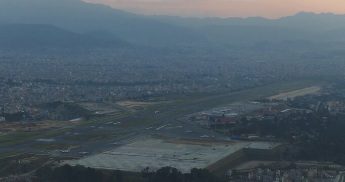 Aerial view of Kathmandu Airport and the city in Nepal during golden hour evening, unmanaged urban city under haze with HIGH AQI, air pollution and unmanaged city with low visibility and TIA runway.
