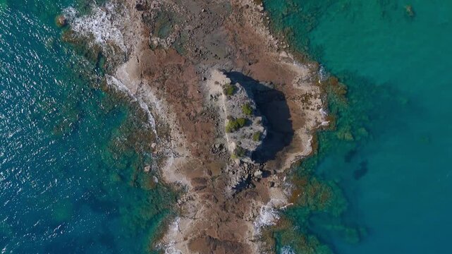 Aerial Bird's Eye View Pan of Rugged Coastal Peninsula and Turquoise Sea in Cyprus