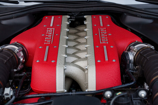 Close up shot of a red Ferrari V12 engine manifold and valve covers, high performance Italian supercar internal combustion engine details and mechanical engineering