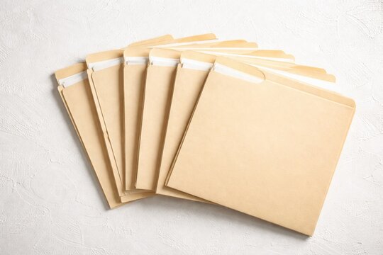 White textured background with fanned Manila folders