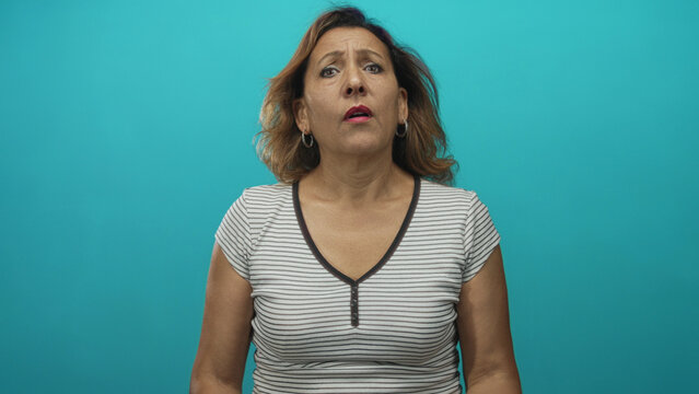 Woman with hands held out, palms up asking for money in a turquoise studio set; financial need pleading.