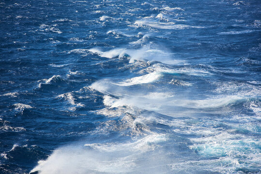 White sea spray and breaking waves on the deep blue surface of the Aegean Sea, South Aegean, Greece, Europe