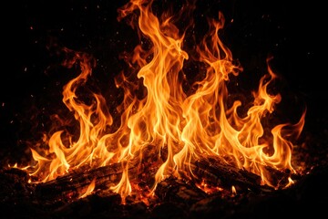Fototapeta premium Intense close up of roaring fire with dancing flames set before a dark black background