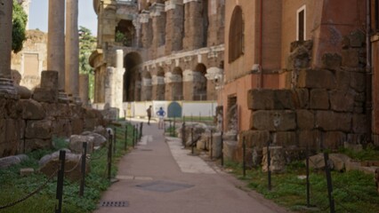 Naklejka premium Soft defocused view of ancient ruins, stone blocks and arches forming a colonnade along a narrow path; background template copyspace calm.