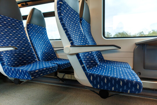 Interior of a deutsche bahn regional train carriage with empty blue seats and a table by the window.