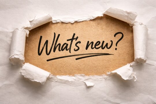 torn paper backdrop displaying handwritten whats new phrase suitable for announcement graphics